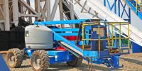 a large blue manlift at a work site