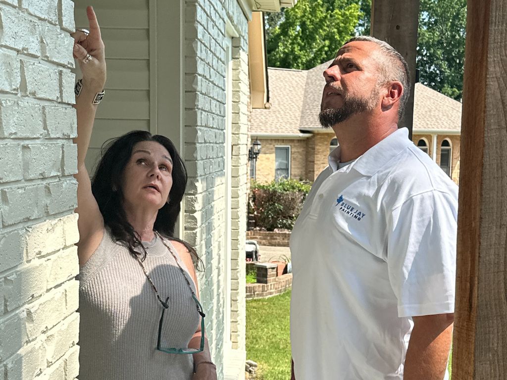 Customer Consultation Professional painter consults homeowner about brick siding